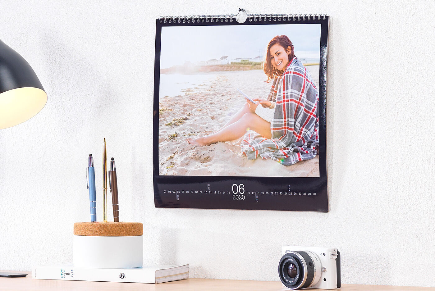 Ein schöner Fotokalender zeigt eine Person beim Lesen am Strand.