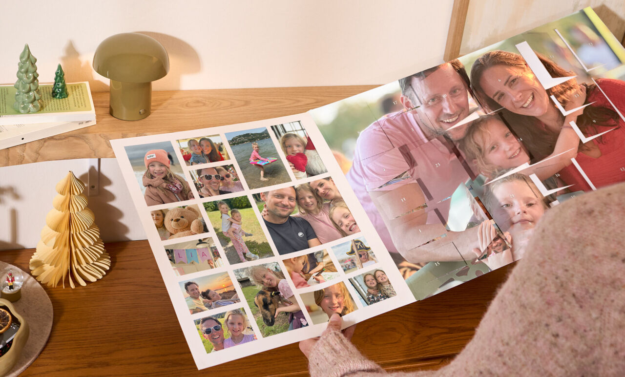 Person hält XXL Foto-Adventskalender in der Hand und betrachtet die herausnehmbare Poster-Collage