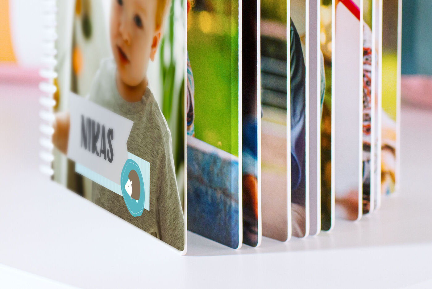 Detailansicht von einem CEWE FOTOBUCH Kids mit bunten Seiten, das auf einem Tisch steht