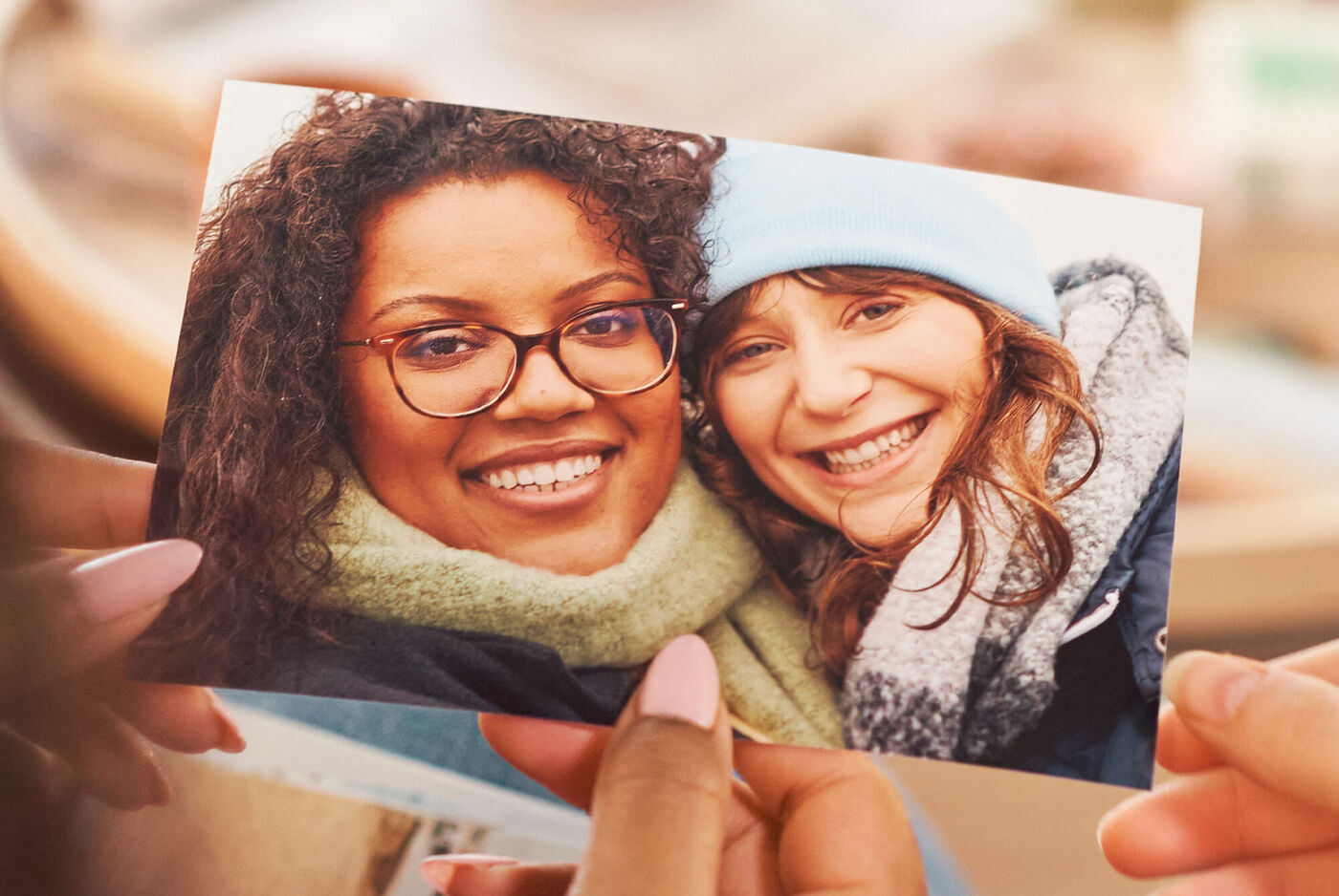 Zwei Hände halten ein Foto von zwei Personen in Winterkleidung und dicken Schals