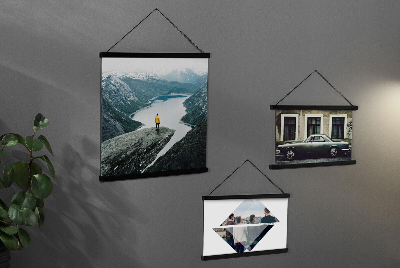 Drei stilvolle Wandbilder hängen an einer grauen Wand, die schöne Berglandschaften und eine alte Karosse zeigen