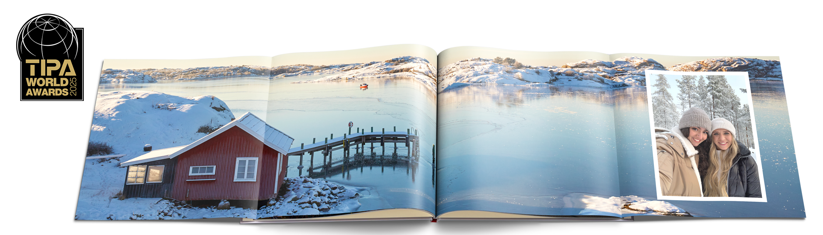Aufgeschlagenes CEWE FOTOBUCH mit Winter-Panoramaseite: vereister See mit roter Hütte und Steg, rechts Foto von zwei Personen im Schnee.