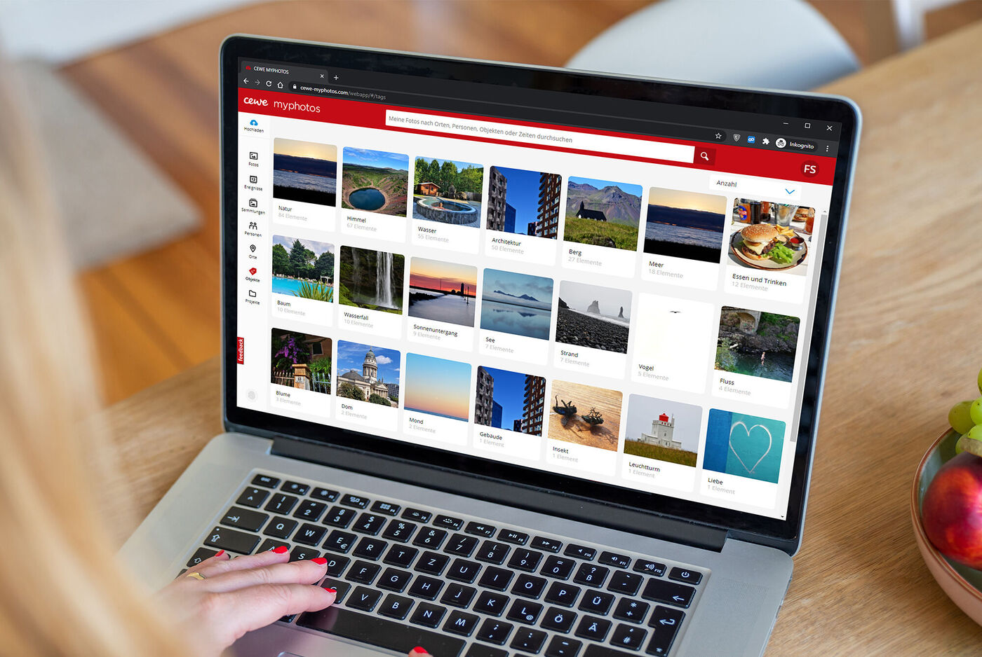Person betrachtet Fotoalben auf Computerbildschirm im heimischen Umfeld