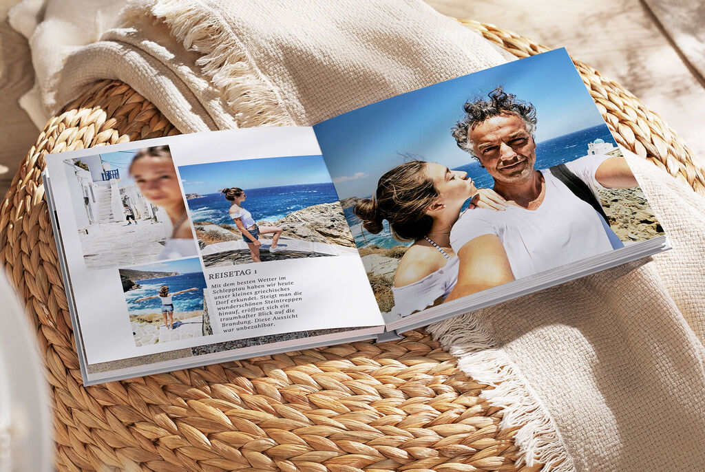 Ein offenes Fotobuch mit Urlaubsbildern von der Küste. Die Seite zeigt ein Paar, das am Strand posiert. Die Farben sind hell und fröhlich, und die Bilder strahlen Freude und Erinnerungen aus.