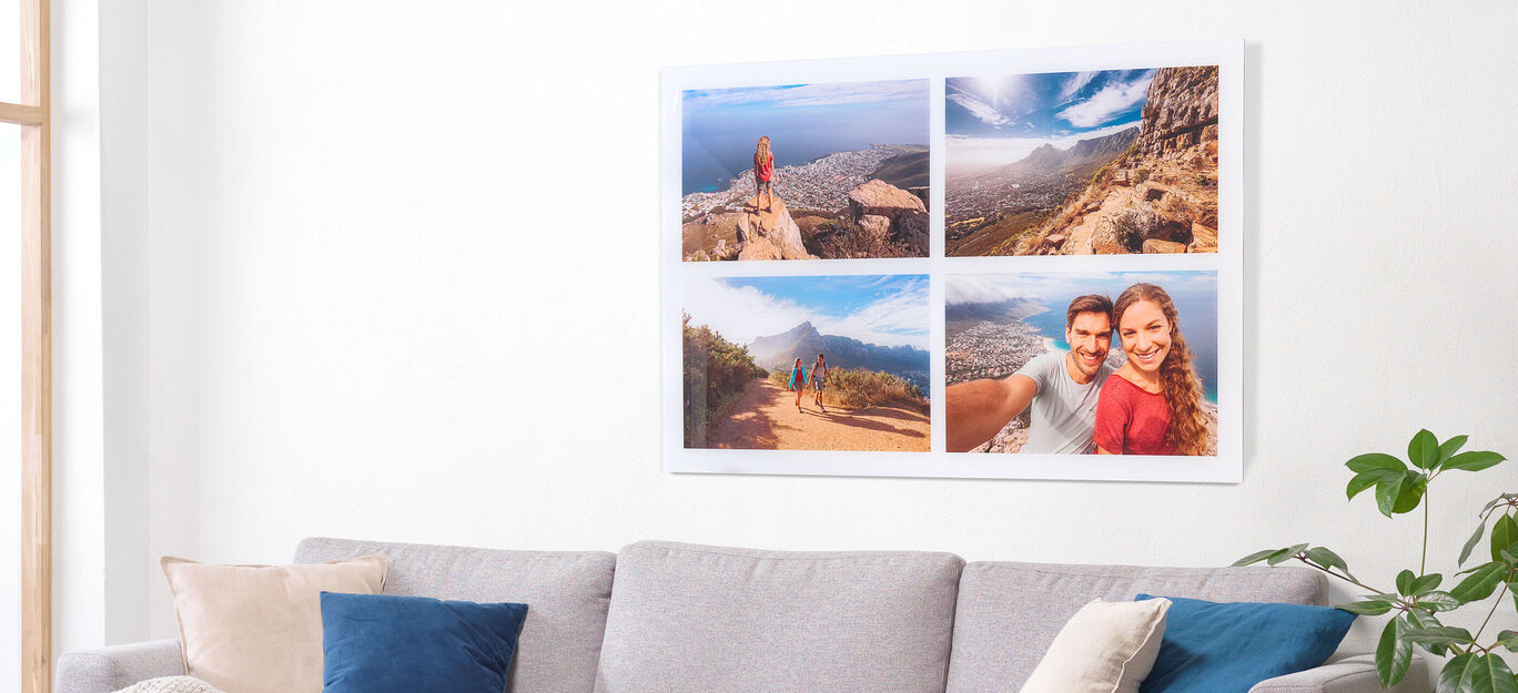 Ein großes Wandbild mit Reisemotiven. Oben links ist eine Person auf einem Berg mit Blick auf die Landschaft. Oben rechts sieht man eine Weitsicht auf eine Stadt. Unten links zeigt das Bild eine schöne Aussicht auf Berge. Unten rechts ist ein Schnappsch