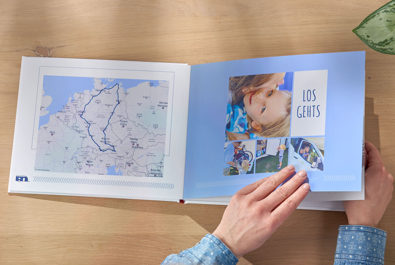 Eine Person blättert durch ein Fotobuch mit Urlaubserinnerungen und Landkarte.