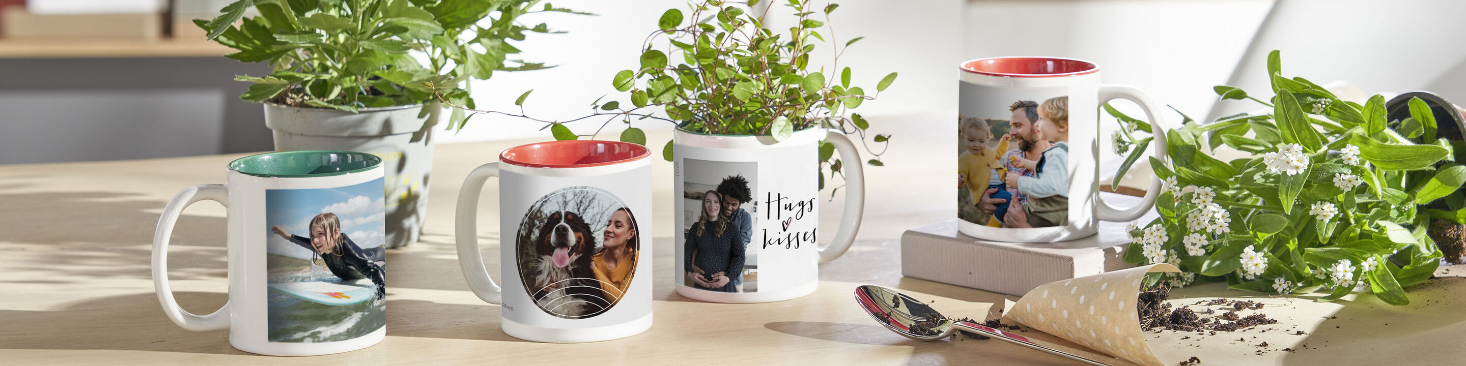 Fünf individuell gestaltete Tassen mit Fotos und Pflanzen auf einem Tisch