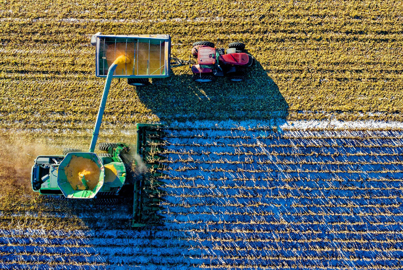 Erntezeit: Ein Traktor und ein Erntewagen sammeln goldene Felder.