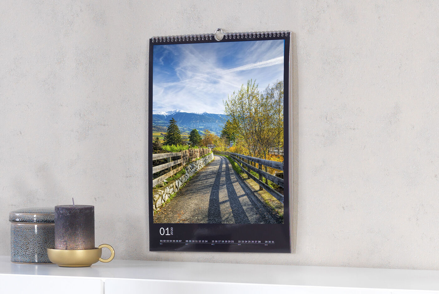 Ein Wandkalender mit einem sonnigen Landschaftsbild eines Weges in der Natur.