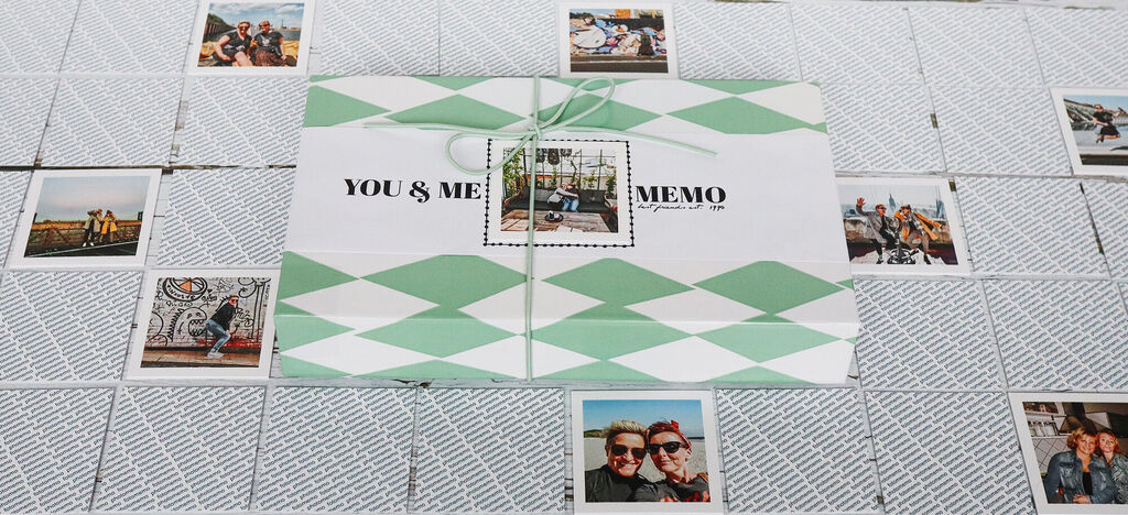 Ein wunderschön gestaltetes Memo-Spiel mit Fotos von gemeinsamen Momente. Die Verpackung zeigt eine grüne und weiße Karomuster-Gestaltung, während die Spielkarten um das Memo herum liegen.
