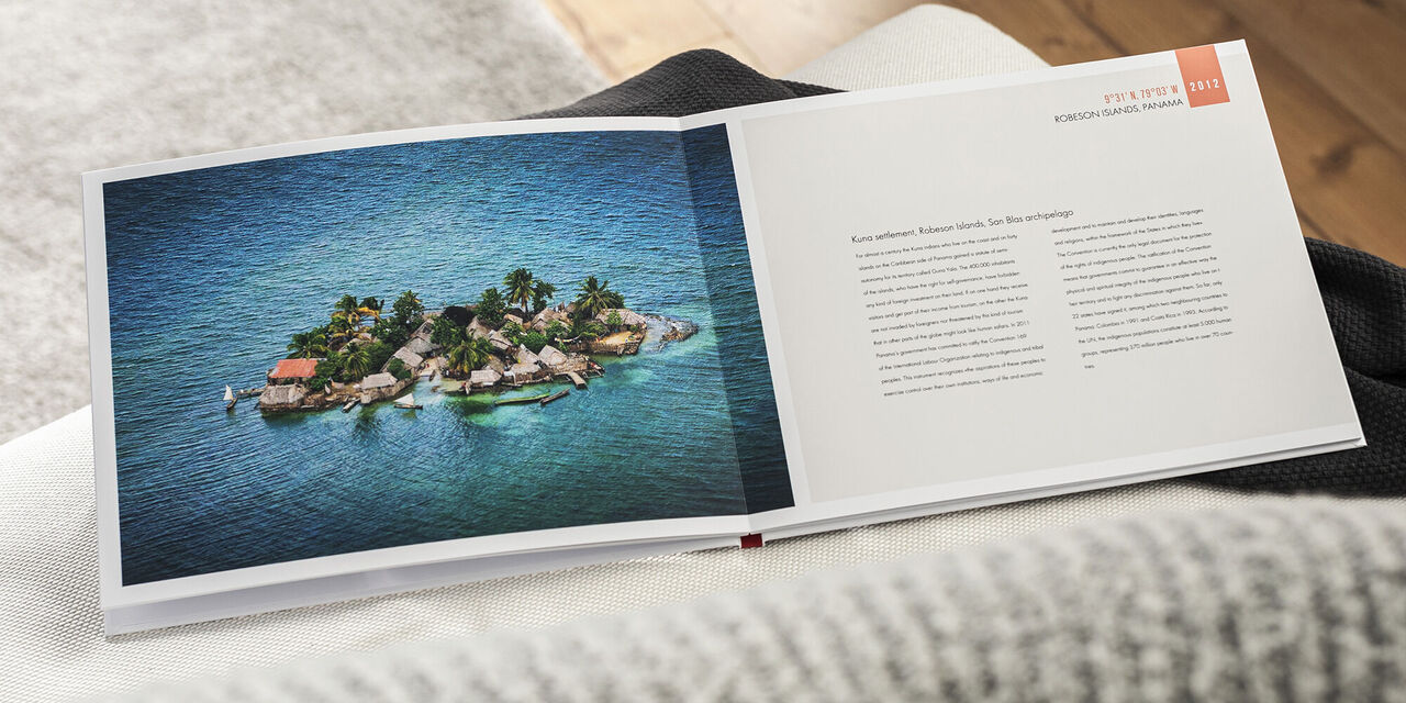 Ein wunderschönes Fotobuch zeigt eine kleine Insel im blauen Wasser mit Palmen und Häusern.