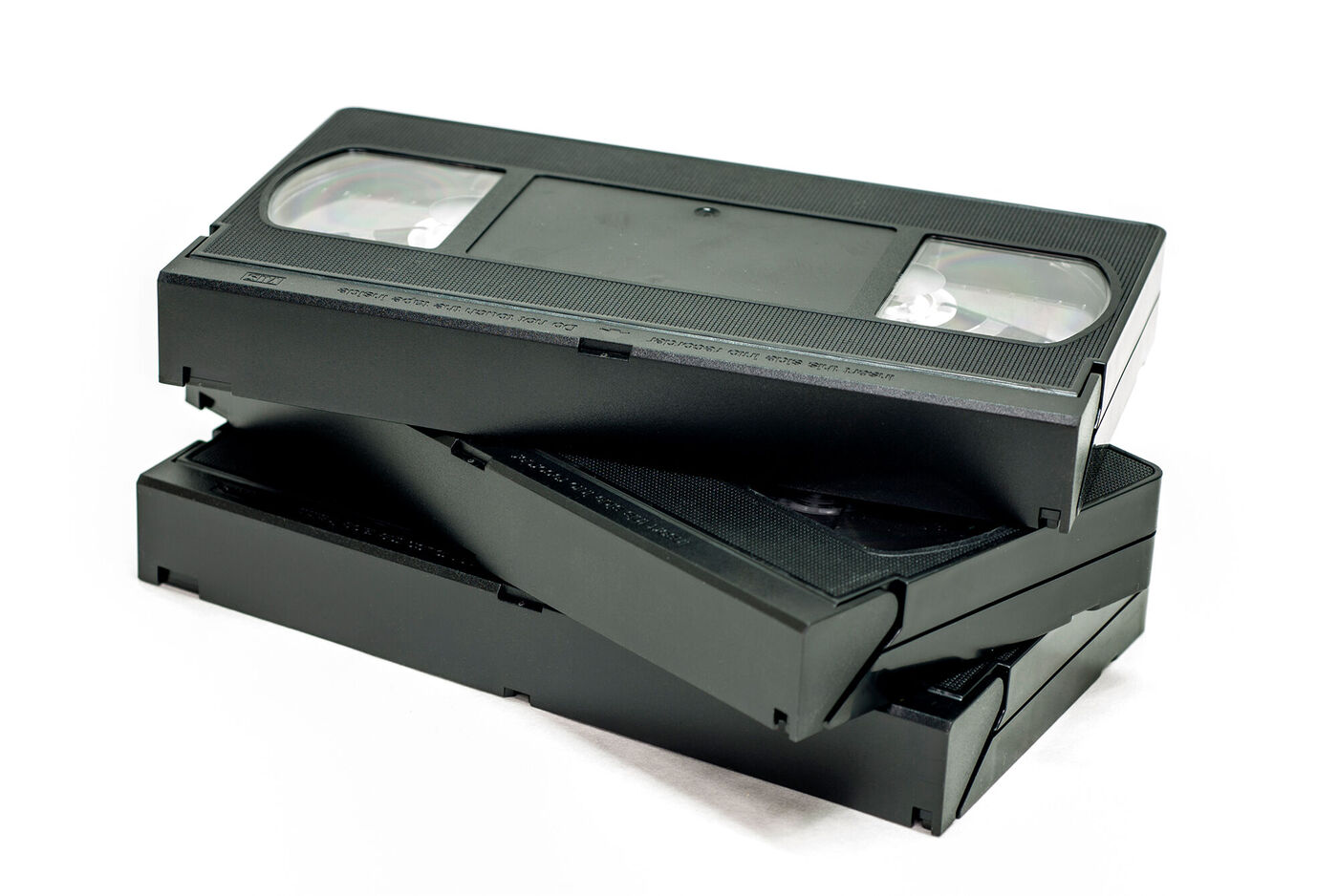Drei übereinander gestapelte VHS-Kassetten auf weißem Hintergrund