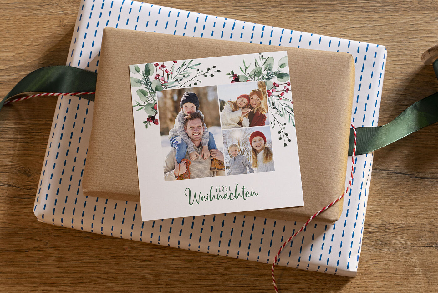 Verpackte Geschenke auf einem Tische mit einer quadratischen Weihnachtskarte mit Familienfotos und tannengrünen Zierelementen.
