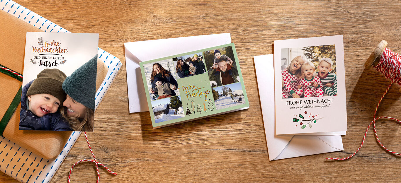Drei Weihnachtskarten liegen auf einem Tisch. Die Eine Karten haben unterschiedliche Designs und Formate. Sie zeigen alle Familienfotos.