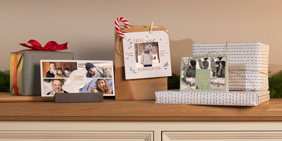 Ein Tisch mit liebevoll verpackten Geschenken in verschiedenen Farben und Formen, dekoriert und verziert mit verschiedenen Weihnachtskarten
