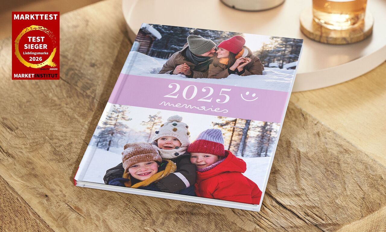CEWE FOTOBUCH 2025 mit fröhlichen Winterbildern einer Familie