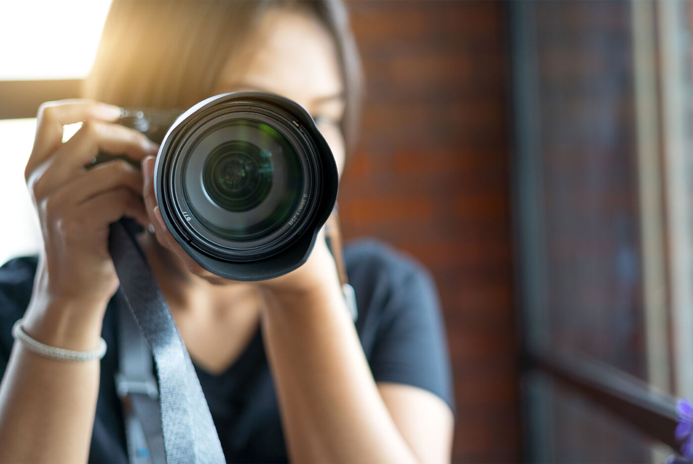 Eine Person hält eine Kamera und fotografiert. Sie ist kreativ und leidenschaftlich und fängt Erinnerungen ein.