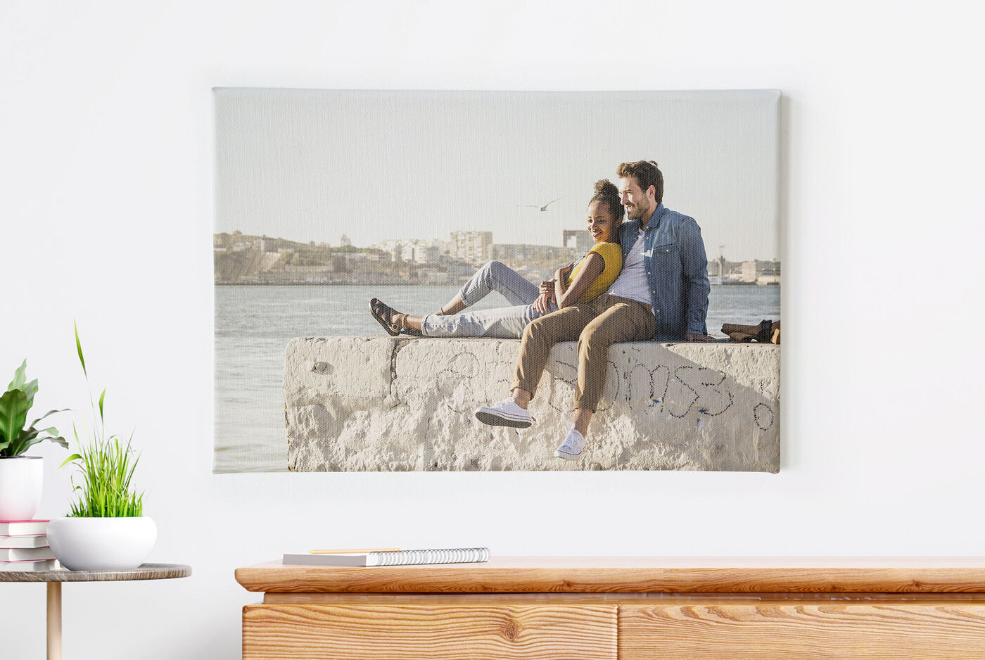 Ein Paar sitzt am Meer auf einer Steinmauer und genießt die Aussicht