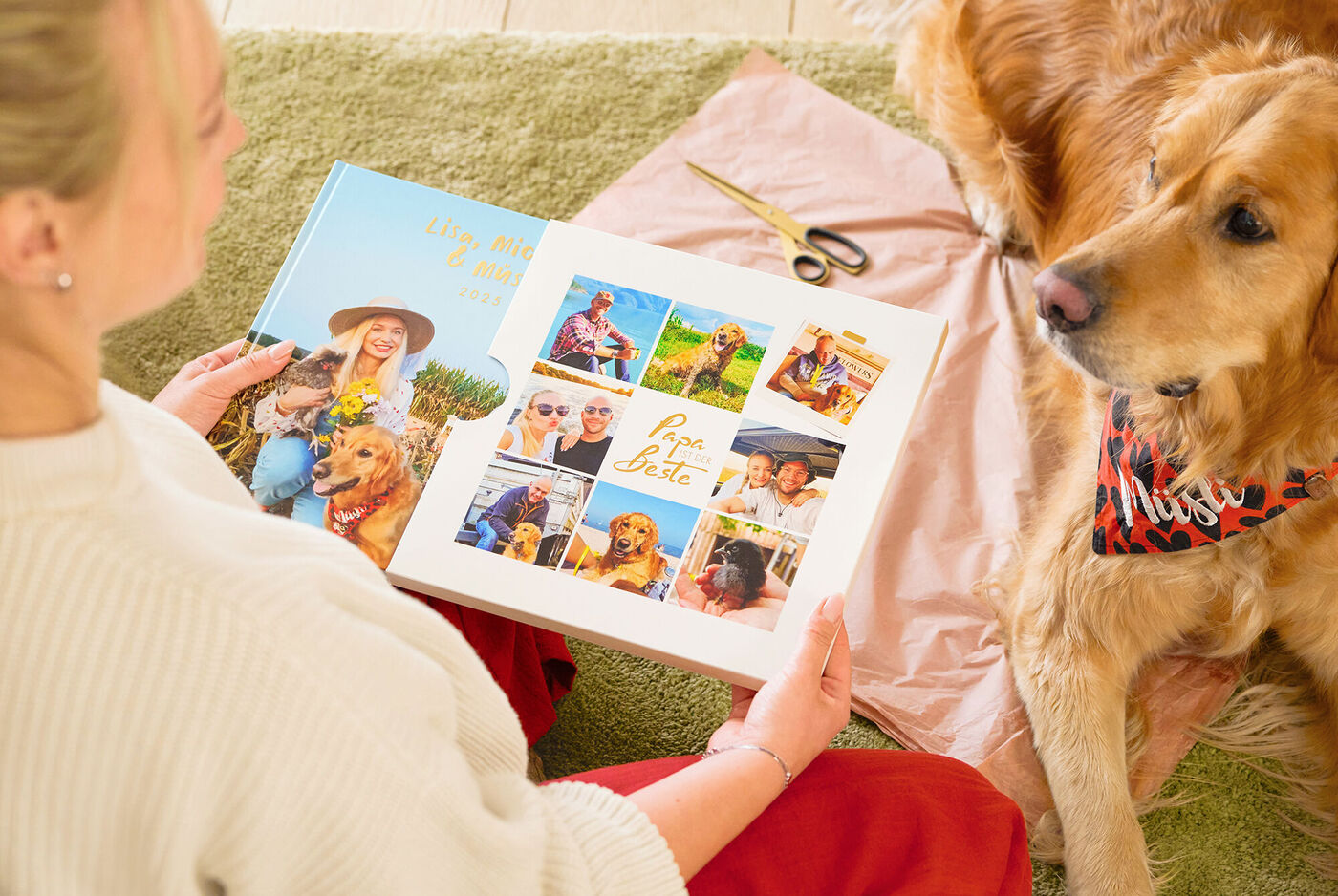 Gemütliche Bescherung am Weihnachtsbaum mit Geschenken, Hund und Tablet, Kerzen sorgen für festliche Stimmung
