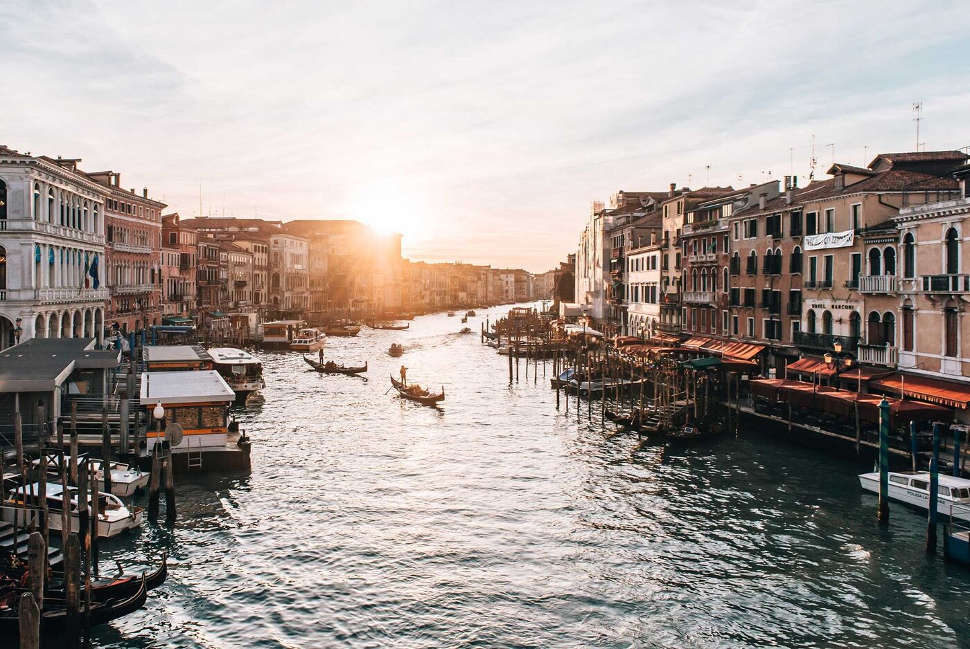 Sonnenuntergang über dem Canal Grande in Venedig, mit Gondeln und Booten.